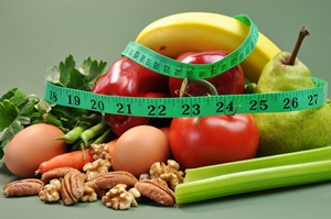 Group of wholesome, organic food, including pear, apple, tomato, eggs, nuts, pecans, walnuts, carrot, banana, and apple, for a healthy diet or slimming New Year resolution.